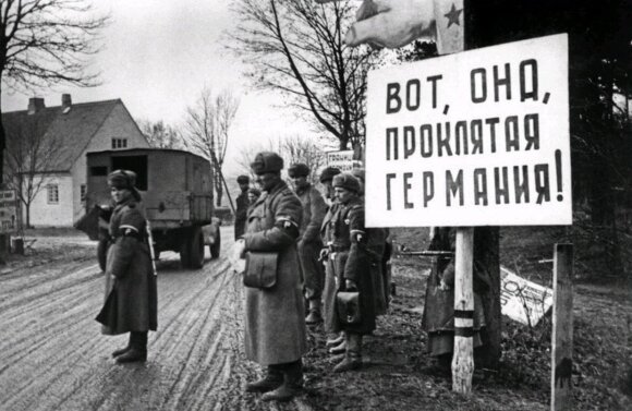 „Štai ji, prakeiktoji Vokietija!“ Raudonosios armijos politiniai darbuotojai nėrėsi iš kailio, kad stiprintų karių neapykantą vokiečiams. Už stendo sustoję kariuomenės eismo reguliavimo tarnybos atstovai.