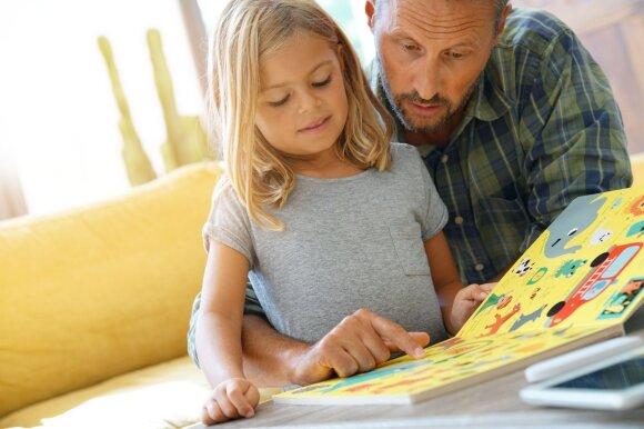 Tėtis ir mergaitė skaito knygą