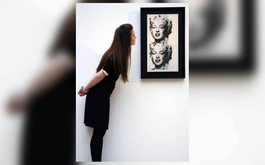 Mergina apžiūrinėja A.Warholo paveikslą “Dviguba Marilyn”, eksponuojamą Londono Christie galerijoje
