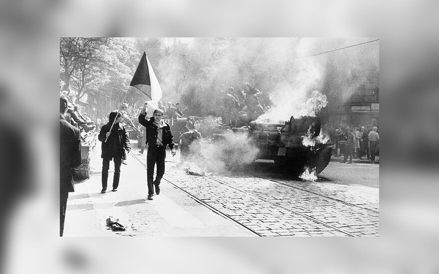 Sovietų Sąjungos įsiveržimas į Čekoslovakiją. Čekoslovakai neša nacionalinę vėliavągreta degančių sovietų tankų. 1968. Praha